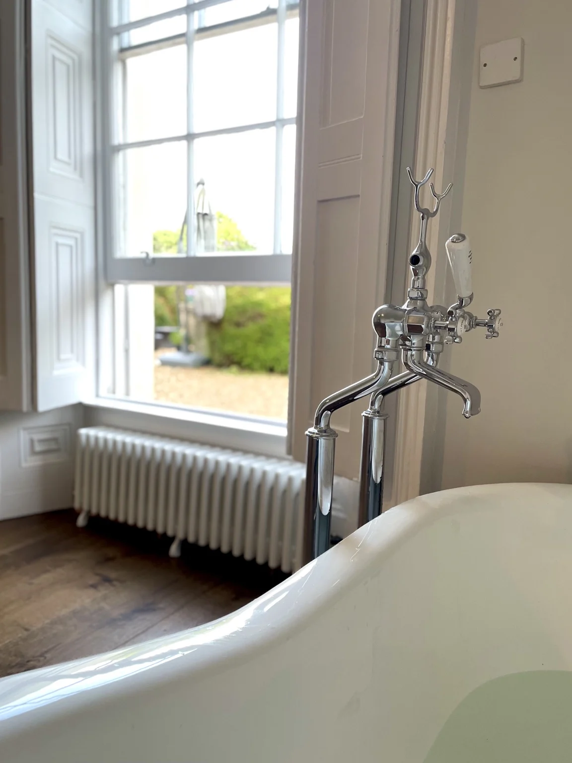 Roll-top bath beneath a Georgian sash window near Keynsham