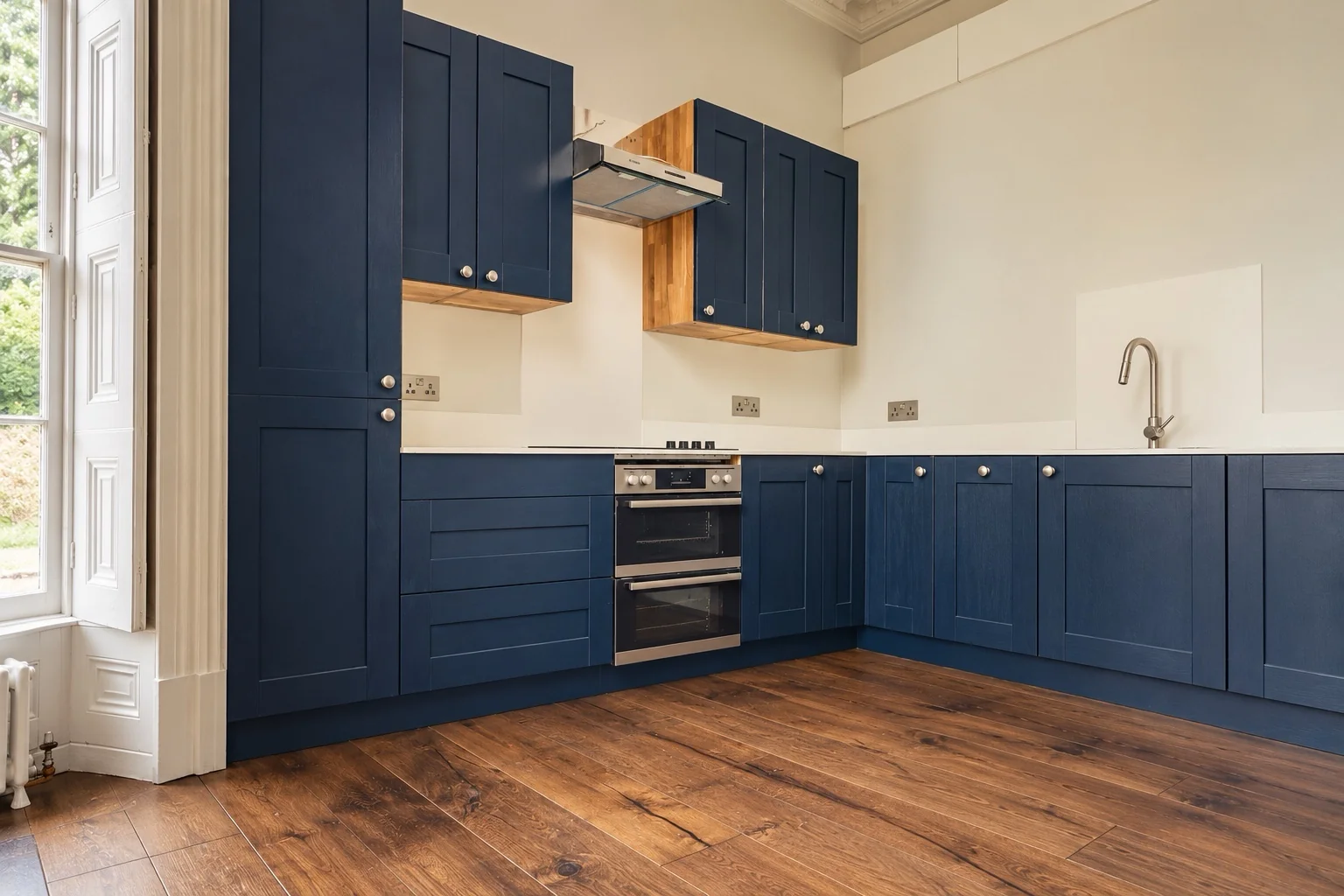 Keynsham kitchen with navy cabinetry and walnut flooring