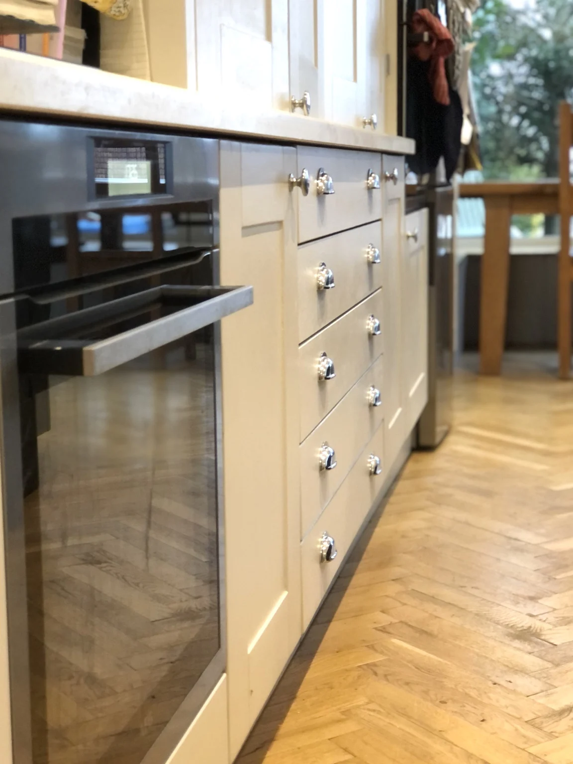 Solid oak kitchen drawers, chrome handles and glued-down solid oak herringbone flooring.